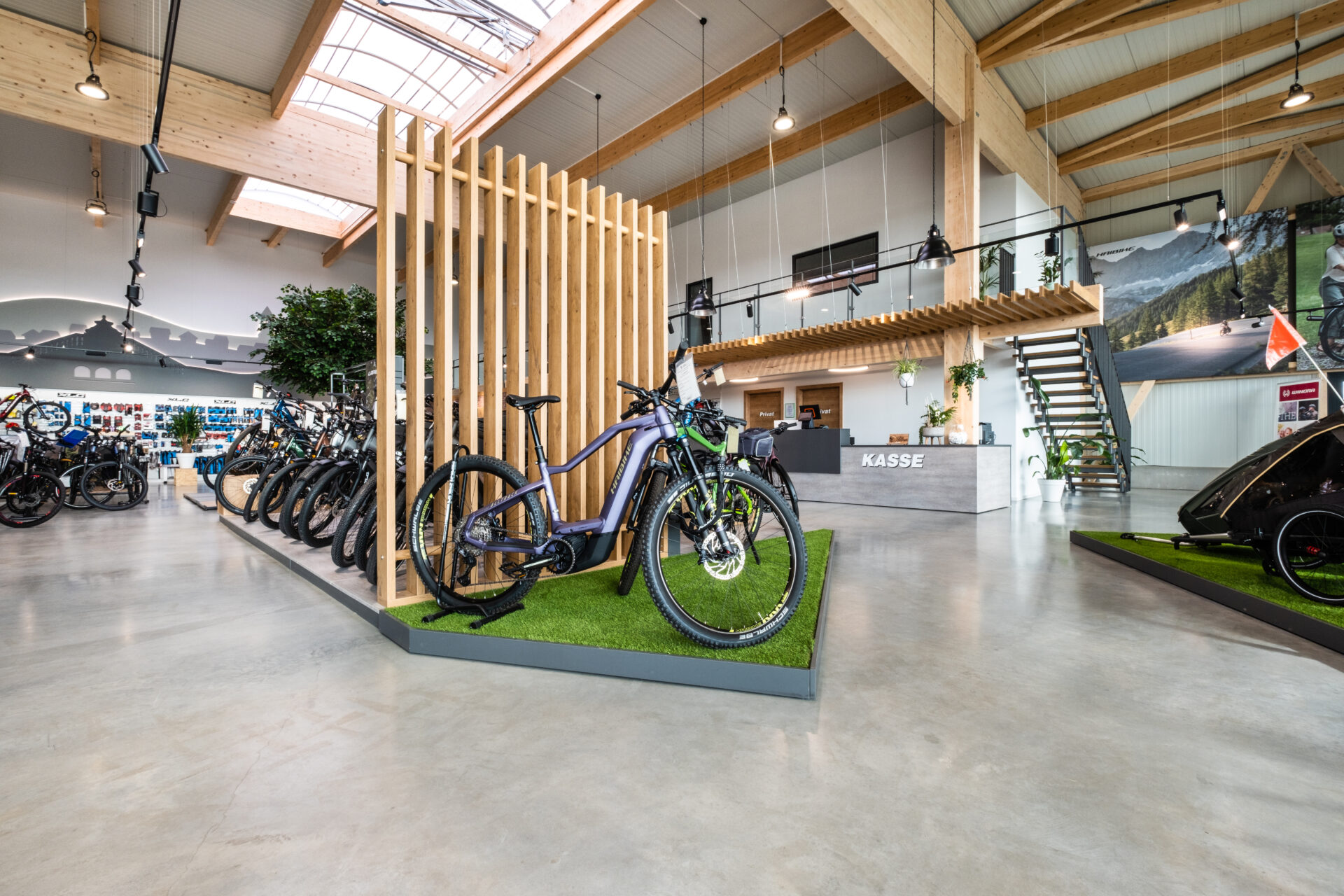 Eingangszone Bike Planet: Inszenierung mit bodennaher Akzentfläche und Design-Elementen zur Trennung von Erlebnis- und Kassenbereich.
