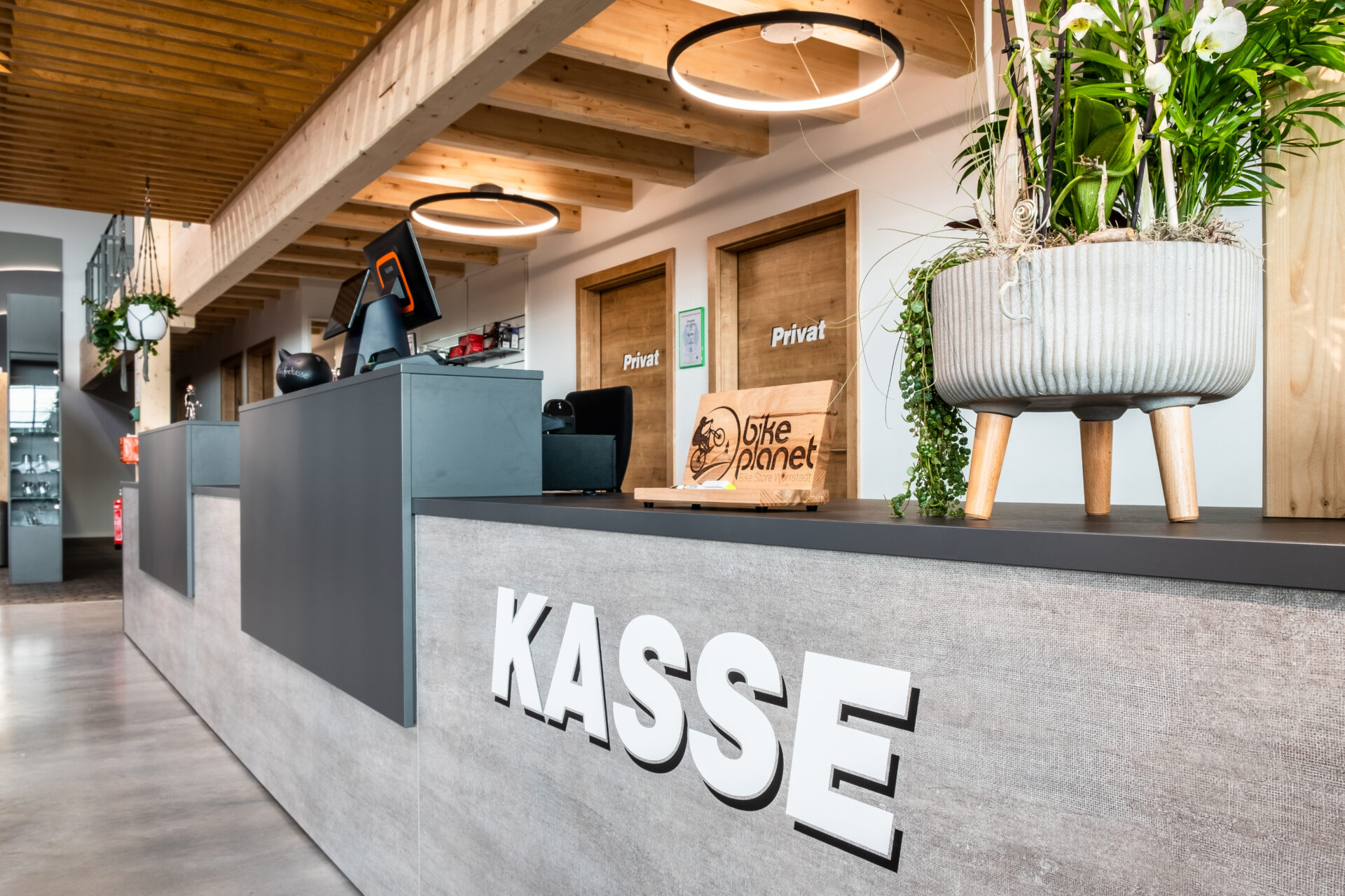 Kassenbereich und POS Bike Planet: Stilvolle, lange Theke mit Holzelementen