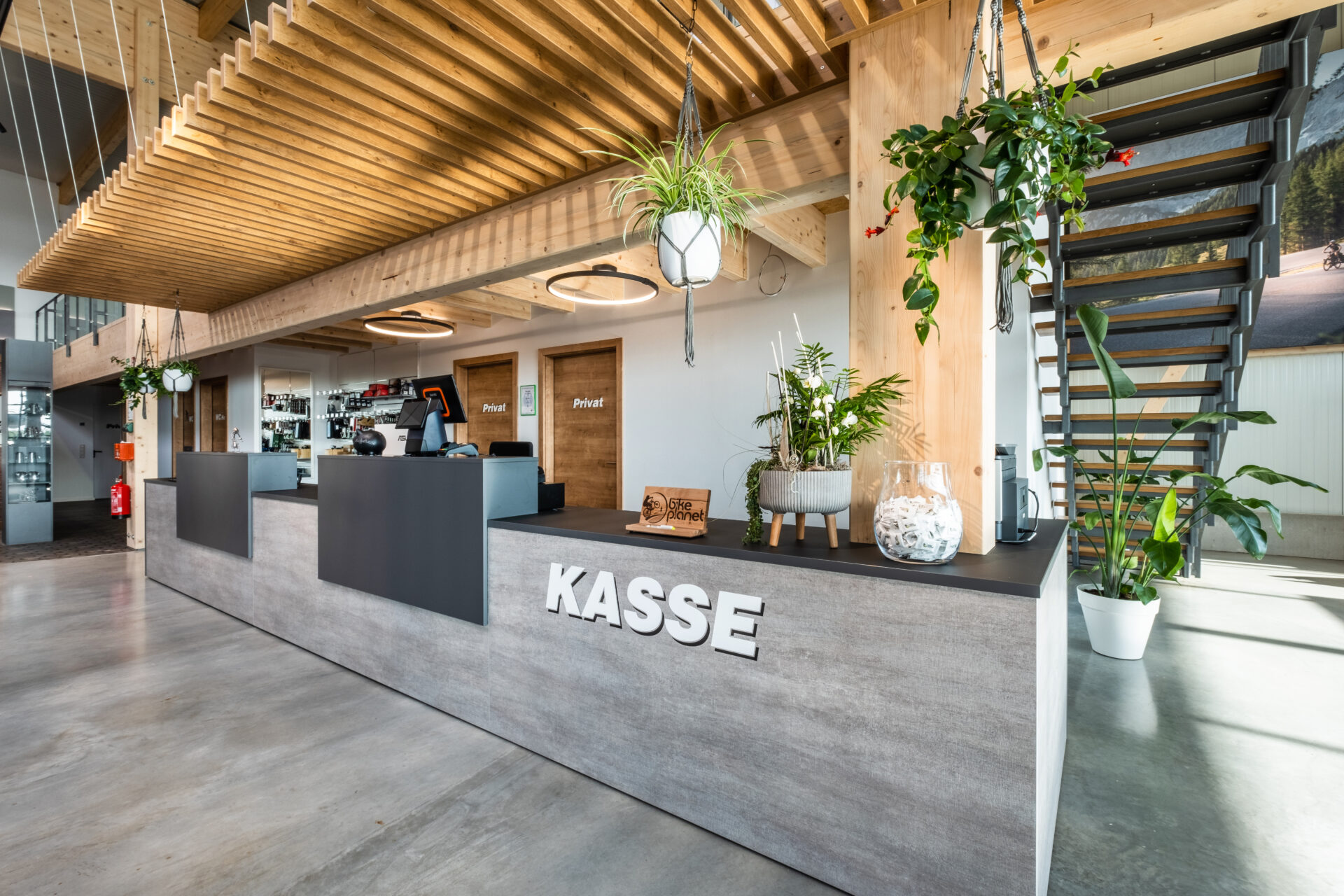 Kassenbereich und POS Bike Planet: Stilvolle, lange Theke mit Holzelementen