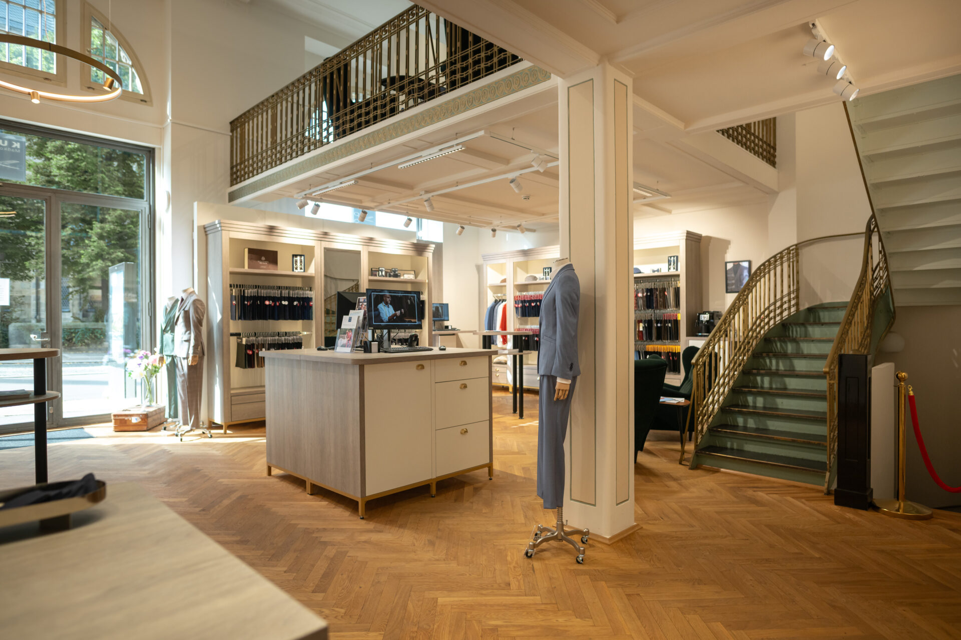 Blick von Kasse zur Denkmalschutz-Treppe: Harmonische Integration von POS-Bereich und maßgefertigten Muster-Möbeln.